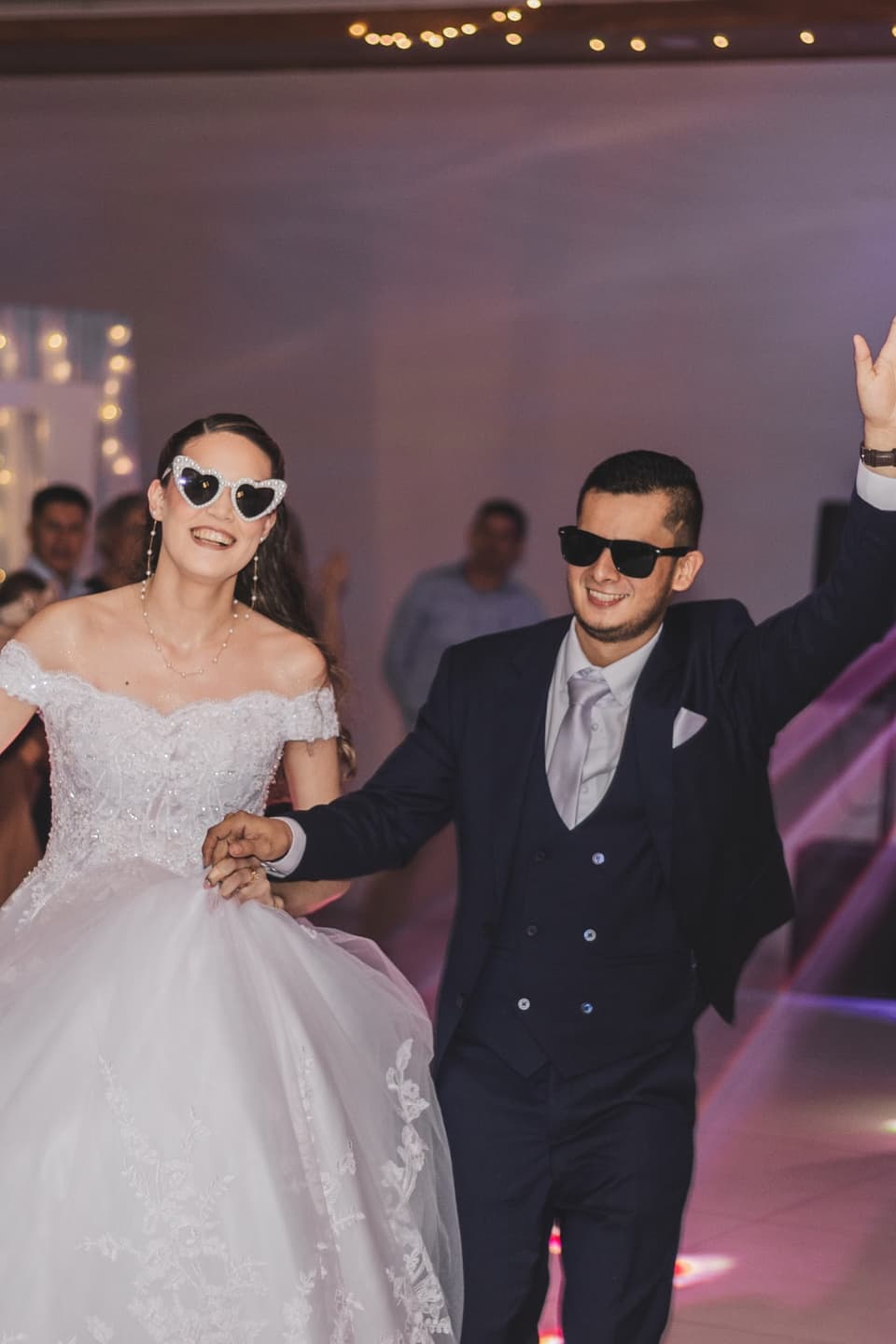 Novios bailando con lentes de sol entre sus invitados en la fiesta