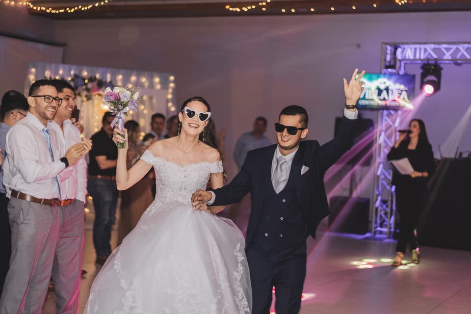 Novios bailando con lentes de sol entre sus invitados en la fiesta